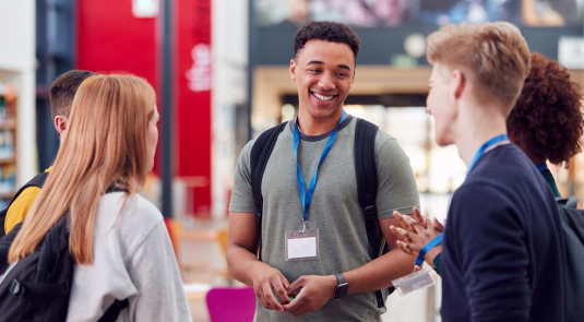 Trois jeunes qui portent un badge discutent lors d'un salon sur le numérique