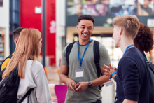 Trois jeunes qui portent un badge discutent lors d'un salon sur le numérique